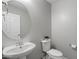 Cozy bathroom with a sleek white sink, round mirror, and modern toilet at 1887 W Desert Seasons Dr, Queen Creek, AZ 85144