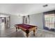 Spacious game room featuring a pool table, gray tile floors, neutral paint and two bright windows at 1887 W Desert Seasons Dr, Queen Creek, AZ 85144