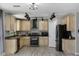 Well-lit kitchen featuring stainless steel appliances, light wood cabinets and a stylish black vent hood at 1887 W Desert Seasons Dr, Queen Creek, AZ 85144