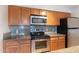 Close up on the kitchen with wood cabinets, gray backsplash, and stainless steel appliances at 200 E Southern Ave # 222, Tempe, AZ 85282
