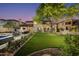 Expansive backyard with lush lawn, mature trees, and outdoor dining area creates a serene retreat at 22406 N 36Th Way, Phoenix, AZ 85050