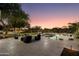 Backyard with a pool, patio, lounge chairs, fire pit, and meticulously manicured greenery under a colorful sky at 22406 N 36Th Way, Phoenix, AZ 85050