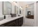 Bathroom featuring double sinks with dark wood cabinets, white countertops, and decorative gray towels at 22406 N 36Th Way, Phoenix, AZ 85050
