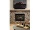 Close-up of fireplace with herringbone tile surround and rustic wood mantel at 22406 N 36Th Way, Phoenix, AZ 85050