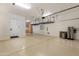 Spacious garage with epoxy flooring, storage cabinets, and suspended shelving at 22406 N 36Th Way, Phoenix, AZ 85050