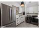Bright laundry room with white cabinets, stainless steel appliances, and quartz countertops at 22406 N 36Th Way, Phoenix, AZ 85050