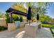 Outdoor kitchen with stainless steel grill, bar seating, and pergola for shaded entertaining at 22406 N 36Th Way, Phoenix, AZ 85050