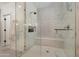 Modern shower with white tile, glass doors, bench and shower products at 22406 N 36Th Way, Phoenix, AZ 85050