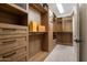 Spacious walk-in closet with custom wood shelving and drawers and carpeted floor at 22406 N 36Th Way, Phoenix, AZ 85050
