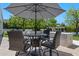 Comfortable outdoor dining area with seating for four and shaded by a large umbrella at 23902 S 202Nd Ct, Queen Creek, AZ 85142