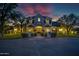 Elegant exterior home view at dusk with well-lit landscaping, beautiful curb appeal, and a stately entrance at 23902 S 202Nd Ct, Queen Creek, AZ 85142