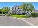 Two-story home featuring a manicured lawn, lush greenery, and a charming brick driveway, set against a clear blue sky at 23902 S 202Nd Ct, Queen Creek, AZ 85142