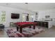 Spacious game room features a pool table, a large TV, and a bar area with a kitchen at 23902 S 202Nd Ct, Queen Creek, AZ 85142