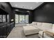 Dark media room with a large sectional sofa and a bay window with shutters at 23902 S 202Nd Ct, Queen Creek, AZ 85142