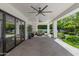 Relaxing covered patio with brick flooring, ceiling fans, and outdoor seating overlooking the lush backyard at 23902 S 202Nd Ct, Queen Creek, AZ 85142