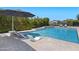 Inviting pool with lounge chairs both in the water and on the surrounding travertine patio at 23902 S 202Nd Ct, Queen Creek, AZ 85142