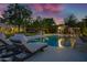 Luxurious backyard with a sparkling pool, lounge chairs, and a covered outdoor entertaining area at 23902 S 202Nd Ct, Queen Creek, AZ 85142