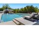 Luxurious pool with a waterfall feature and comfortable lounge chairs for relaxing outdoors at 23902 S 202Nd Ct, Queen Creek, AZ 85142
