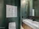 Stylish powder room featuring green walls, a modern sink, and decorative artwork at 23902 S 202Nd Ct, Queen Creek, AZ 85142