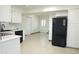 Spacious kitchen with white cabinets and a black refrigerator, and a view to the front door at 2902 W Bloomfield Rd, Phoenix, AZ 85029