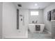 Elegant bathroom with a freestanding tub, walk-in shower, and modern fixtures at 3336 E Earll Dr, Phoenix, AZ 85018