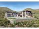 Stunning modern home featuring stone accents, black trim, large windows, and a luxurious pool with desert landscaping at 3367 N Highlands Dr # 39, Buckeye, AZ 85396