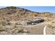 A view showing a desert landscape with a stone wall feature and a paved road intersection at 3367 N Highlands Dr # 39, Buckeye, AZ 85396