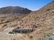 A view showing a desert landscape with a stone wall feature and desert vegetation at 3367 N Highlands Dr # 39, Buckeye, AZ 85396