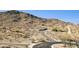 A hilltop street view showcasing a desert lot with a stone wall feature at 3367 N Highlands Dr # 39, Buckeye, AZ 85396