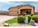 Lovely single-level house highlighting a two-car garage, an inviting entrance, and mature shrubbery creating a warm ambiance at 36064 N Murray Grey Dr, San Tan Valley, AZ 85143