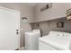 Convenient laundry room featuring modern washer and dryer, plus storage shelf, and charming decor at 36064 N Murray Grey Dr, San Tan Valley, AZ 85143
