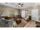 Cozy living room featuring a ceiling fan, a comfortable sofa with decorative pillows, and lots of natural light from a large window at 36064 N Murray Grey Dr, San Tan Valley, AZ 85143