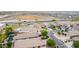 Aerial view showcasing homes in a well-maintained neighborhood, highlighting mature trees and nearby roadways at 36064 N Murray Grey Dr, San Tan Valley, AZ 85143