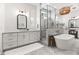 Modern bathroom features a glass enclosed shower, soaking tub, and stylish vanity with ample storage at 3616 N 54Th Pl, Phoenix, AZ 85018