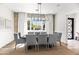 This dining room features a modern chandelier, exposed brick accent wall, and a large window for natural light at 3616 N 54Th Pl, Phoenix, AZ 85018