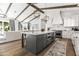 Spacious kitchen with white cabinetry, stainless appliances, large center island with stone countertops, and wooden beam ceiling at 3616 N 54Th Pl, Phoenix, AZ 85018