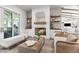 A cozy living room has a fireplace with whitewashed brick, mantel, and hearth plus sliding glass doors to the patio at 3616 N 54Th Pl, Phoenix, AZ 85018