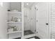 Updated shower featuring subway tile, glass door, and built-in shelving at 3616 N 54Th Pl, Phoenix, AZ 85018