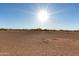 Expansive land featuring distant buildings under a clear, sunny sky at 3747 S Mammoth Dr, Casa Grande, AZ 85193