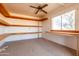 Empty room with shelving, ceiling fan, and a window overlooking the outdoors. Showing some needed repair at 3747 S Mammoth Dr, Casa Grande, AZ 85193