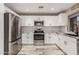 Modern kitchen featuring white cabinets, stainless steel appliances, and granite countertops at 4262 E Sundance Ave, Gilbert, AZ 85297
