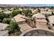 Aerial view showcasing two homes, a circular driveway, a sparkling pool, and lush landscaping in a desert community at 4616 E Gold Poppy Way, Phoenix, AZ 85044