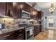 Gourmet kitchen with granite countertops, stainless steel appliances, and dark wood cabinetry at 4616 E Gold Poppy Way, Phoenix, AZ 85044