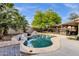 Inviting backyard pool featuring rock accents and lush landscaping, complemented by a covered outdoor seating area at 4616 E Gold Poppy Way, Phoenix, AZ 85044