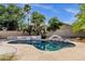 Backyard pool surrounded by lush landscaping and rock features, creating a serene and private outdoor oasis at 4616 E Gold Poppy Way, Phoenix, AZ 85044