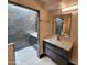 Bathroom featuring modern vanities and walk-in shower with dark grey tile at 4830 N 72Nd Way, Scottsdale, AZ 85251