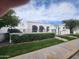 Beautiful white stucco house with an arched entryway, black awnings, and well-manicured landscaping at 4830 N 72Nd Way, Scottsdale, AZ 85251