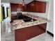 Well lit kitchen features stainless steel appliances, granite countertops, dark wood cabinetry and modern backsplash at 4830 N 72Nd Way, Scottsdale, AZ 85251