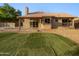 Private backyard featuring an artificial lawn, covered patio, and neutral gravel at 5976 W Alameda Rd, Glendale, AZ 85310