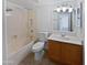 Functional bathroom featuring a shower-tub combo, vanity, and neutral tiling at 5976 W Alameda Rd, Glendale, AZ 85310